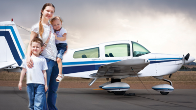 family standing with small airplane
