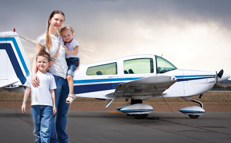 family standing with small airplane