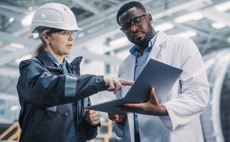 engineer and mechanic looking at laptop