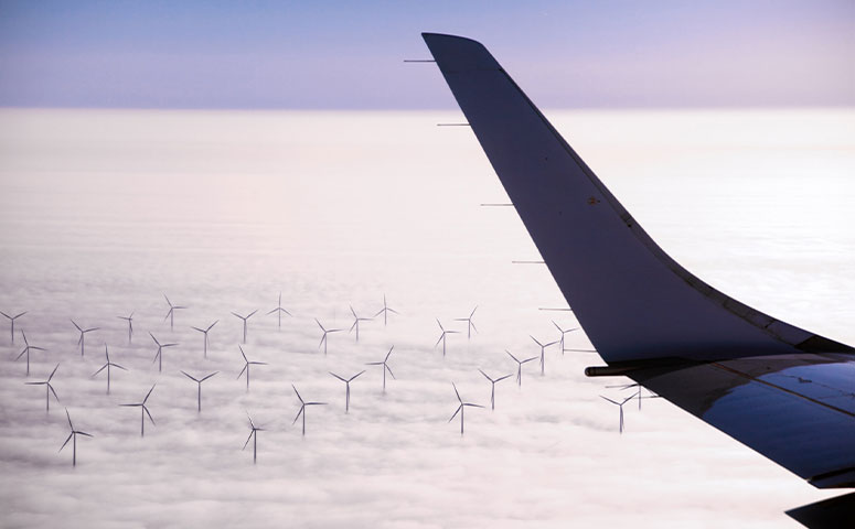 airplane flying over wind farm