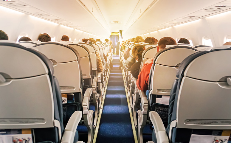 aircraft cabin with rows of seats down the aisle