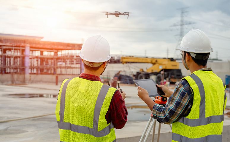 construction workers operating a drone
