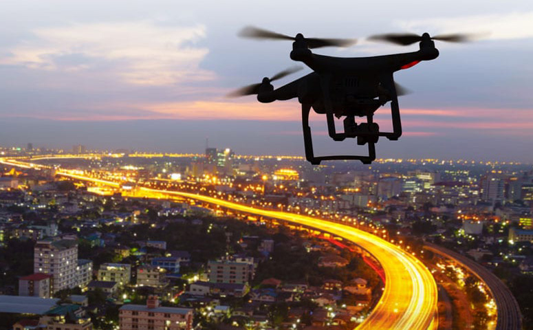 drone in flight over city at dusk